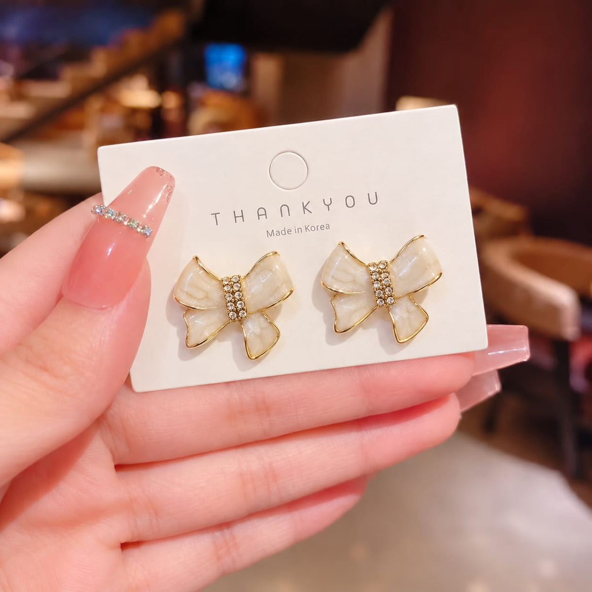 ivory enamel bow-shaped stud earrings with rhinestone accents