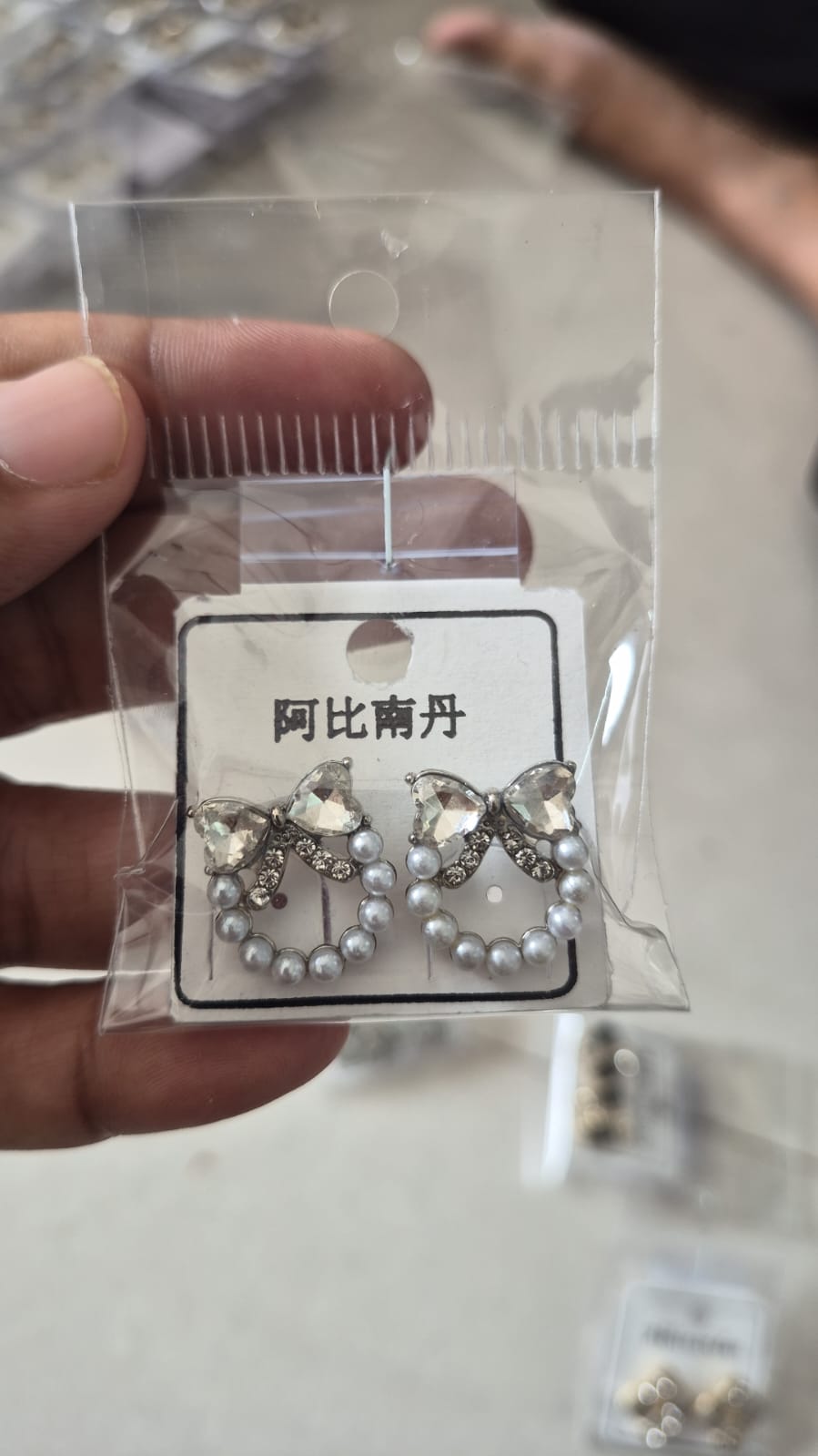 bow and faux pearl wreath stud earrings featuring clear crystals.