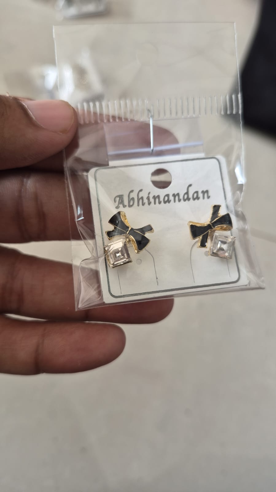 black enamel bow paired with a sparkling square crystal