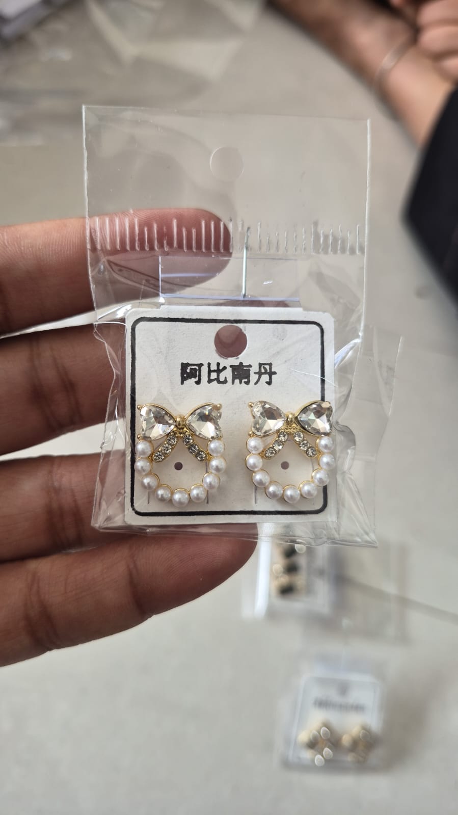 bow and faux pearl wreath stud earrings featuring clear crystals.