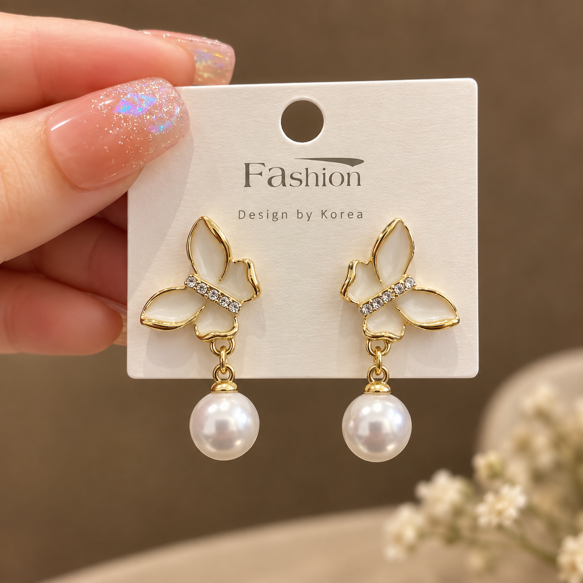 white butterfly wings accented with dangling pearl drop.