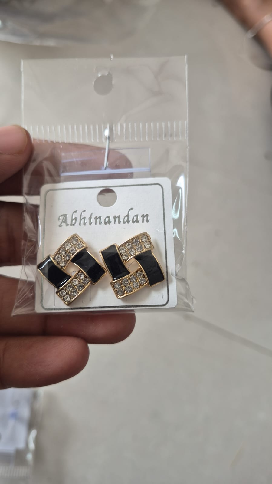 gold-plated geometric stud earrings featuring black enamel