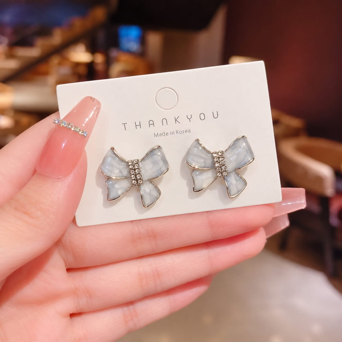 ivory enamel bow-shaped stud earrings with rhinestone accents