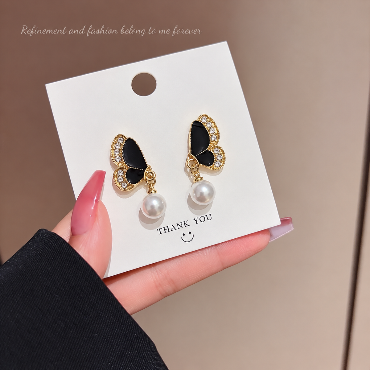 butterfly drop earring featuring black enameled wings accented
