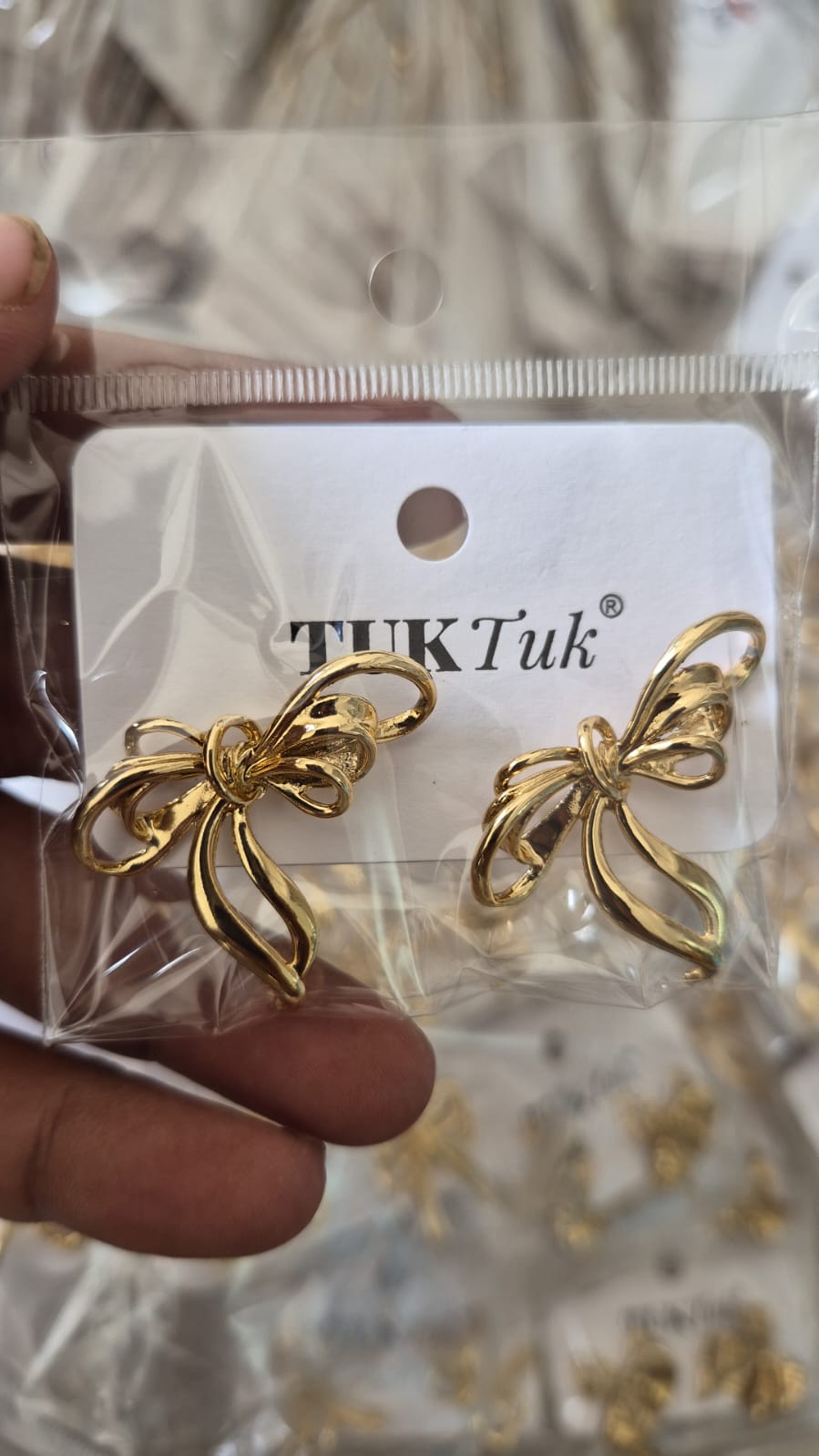 Anti tarnished gold-toned bow earrings with a polished, looped ribbon design