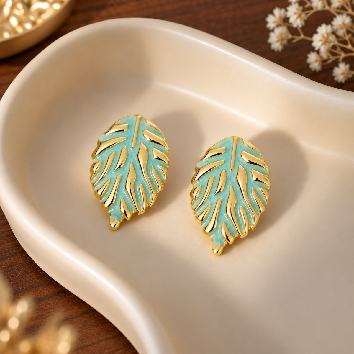leaf stud earrings featuring a textured metallic vein pattern