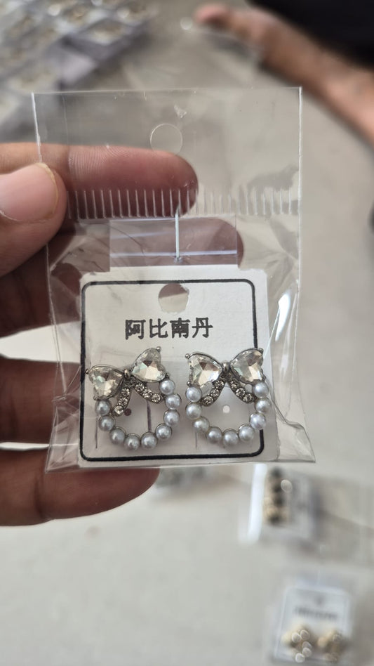 bow and faux pearl wreath stud earrings featuring clear crystals.