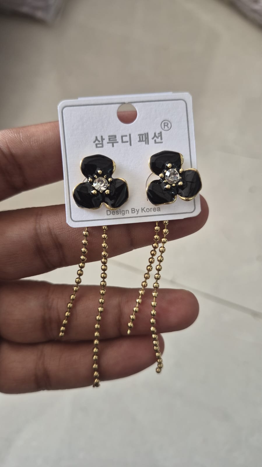 black flower earring with hanging beaded chain dangles.