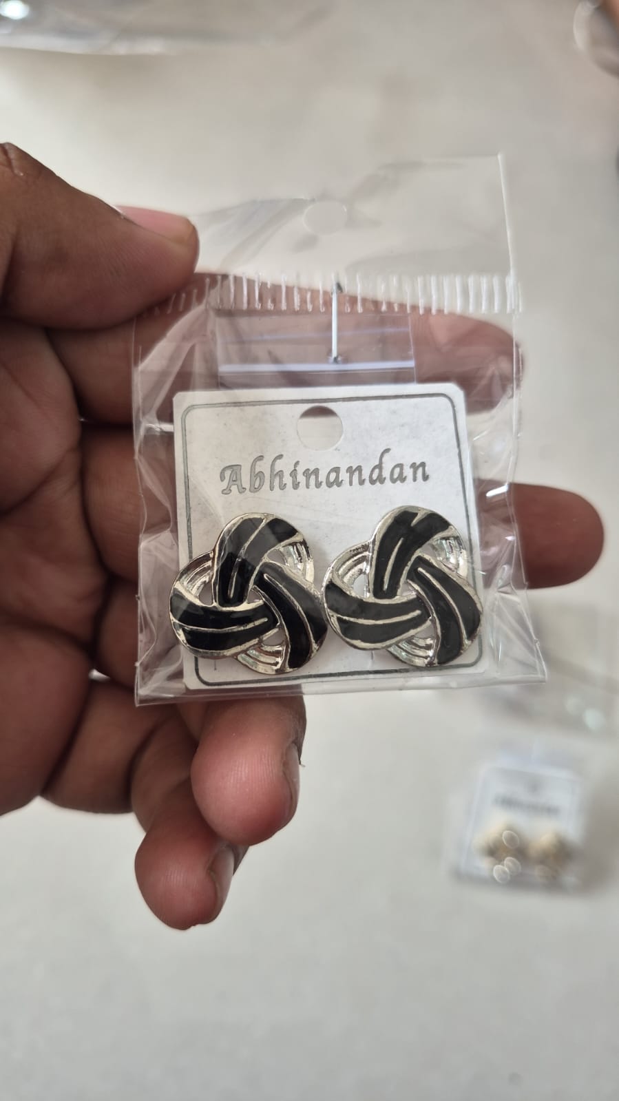 silver-toned intertwined knot design accented with black enamel earring