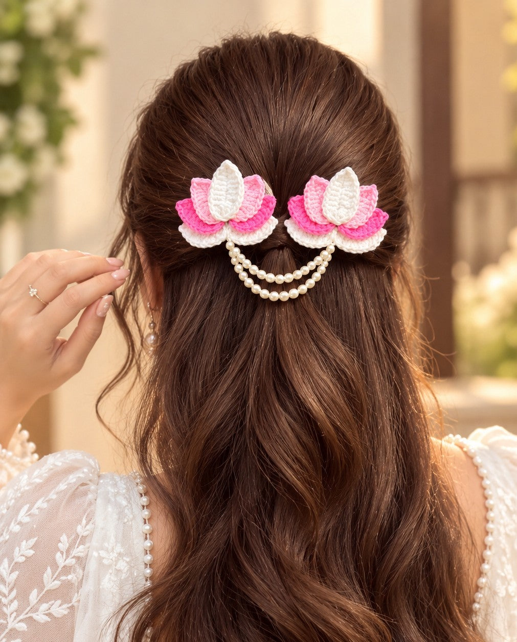 handmade crochet lotus flower hair clip featuring pink and white yarn petals connected by a double pearl bead chain