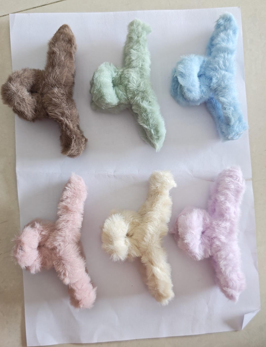 Soft, plush faux fur hair claw clips arranged in a set of six charming pastel and neutral colors.