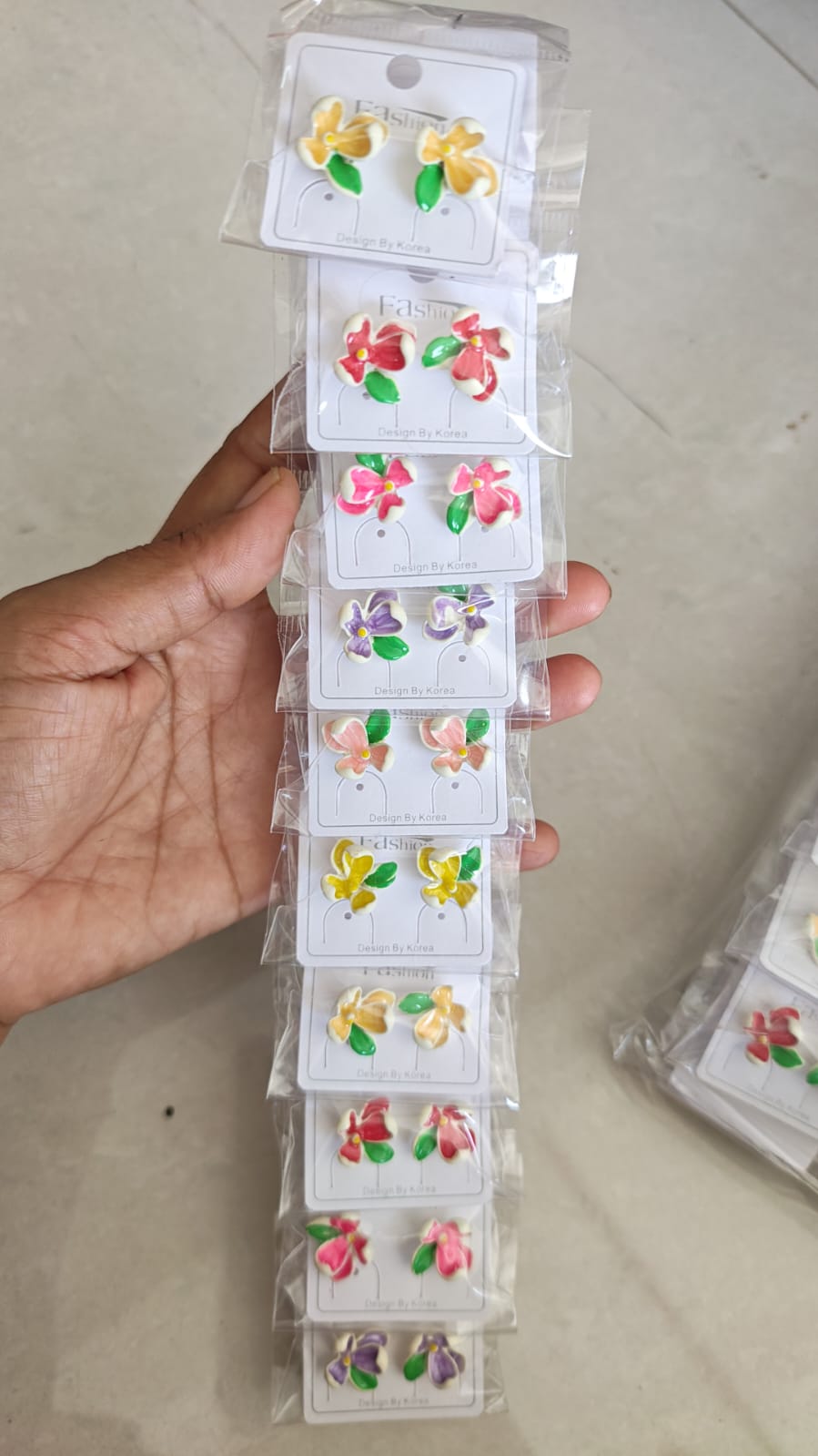 Flower Stud Earrings, featuring colorful enamel floral designs with green leaf accents.
