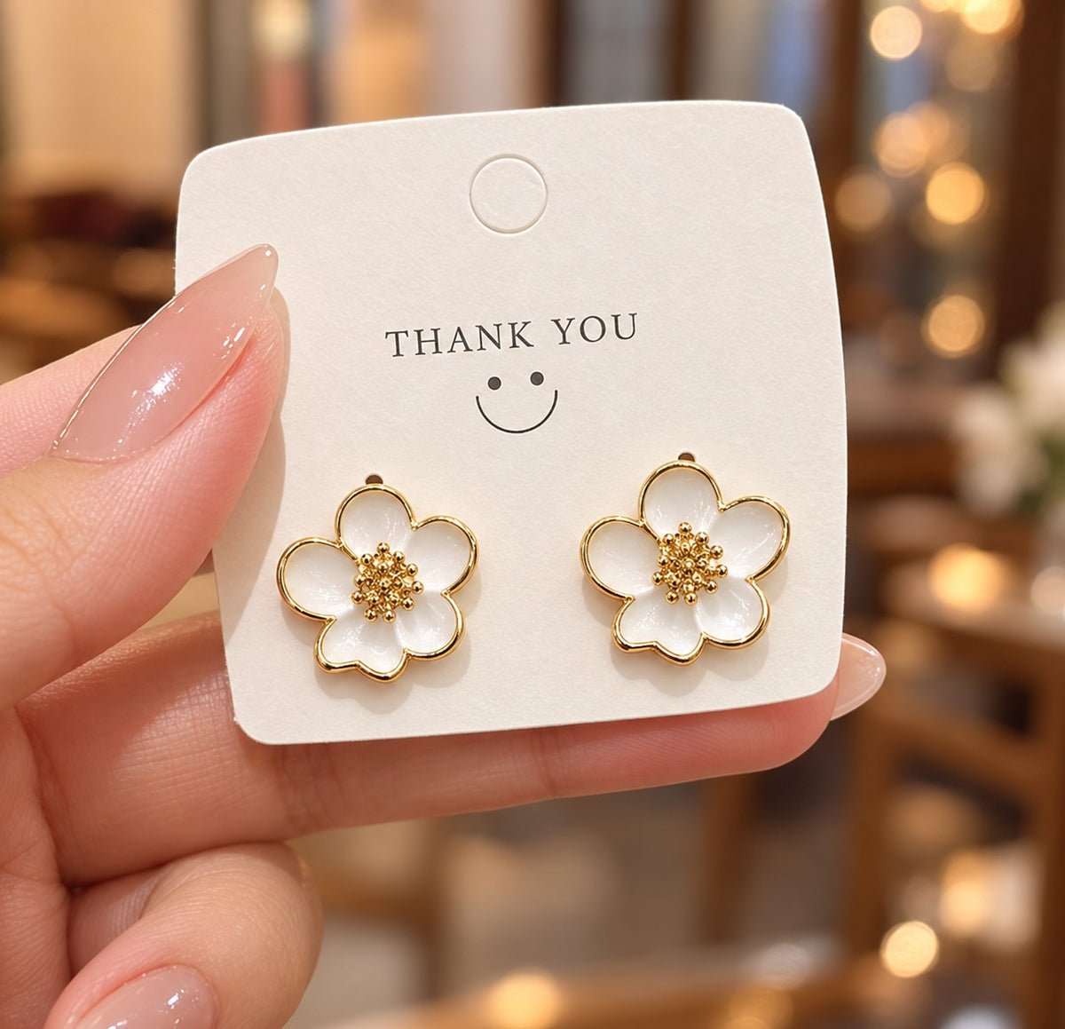 gold-toned and white floral-shaped stud earrings