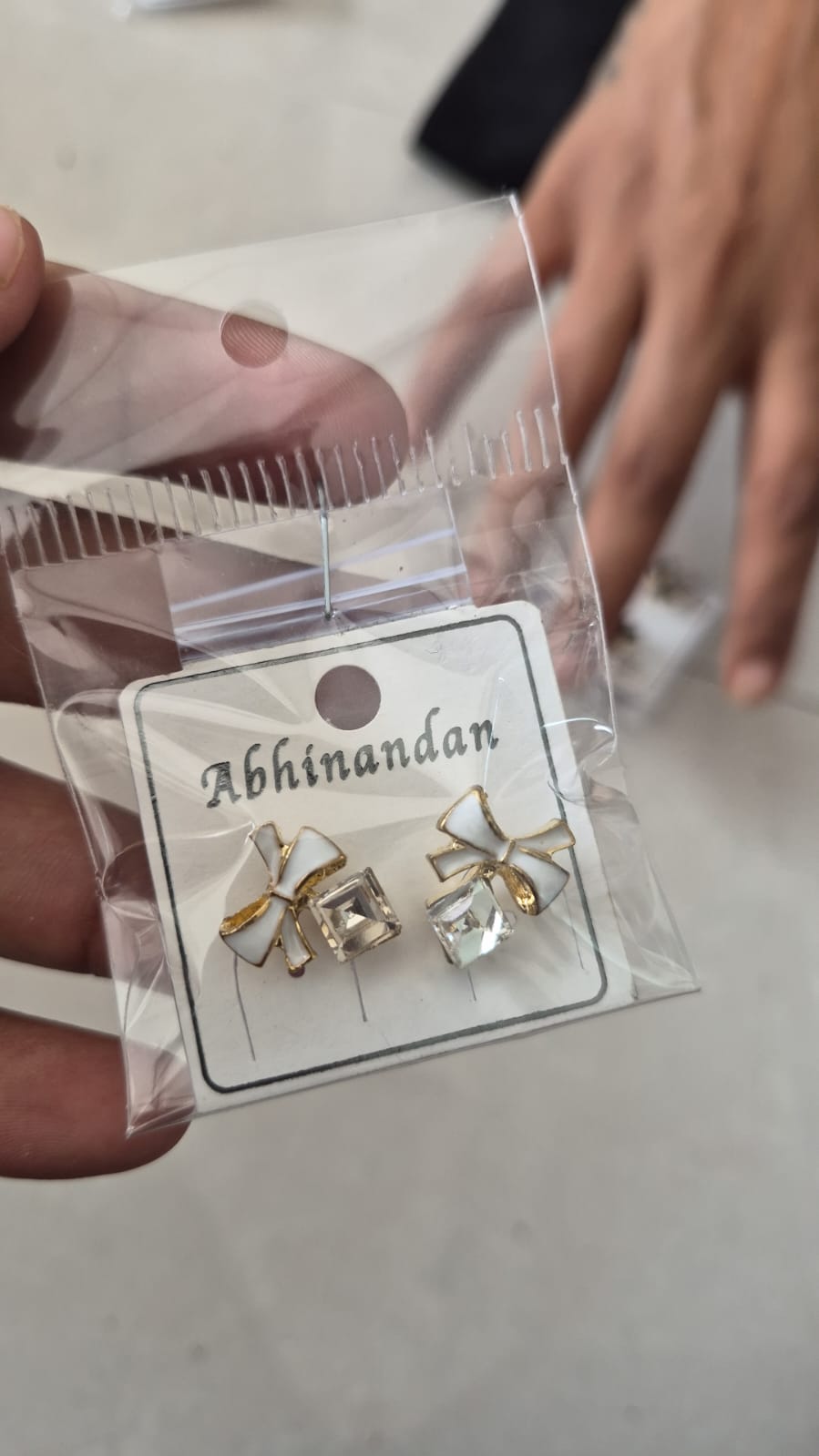 White enamel bow paired with a sparkling square crystal