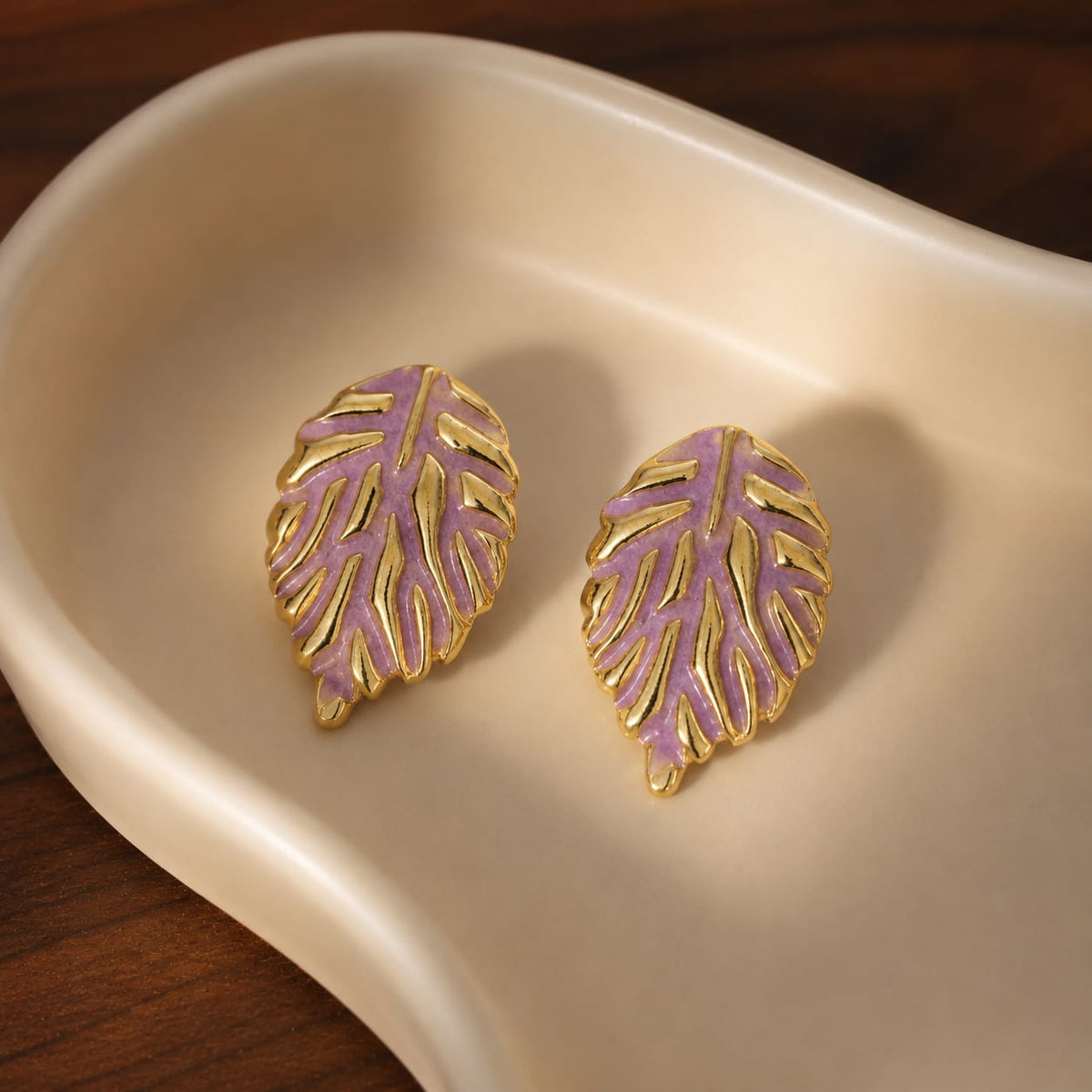 leaf stud earrings featuring a textured metallic vein pattern