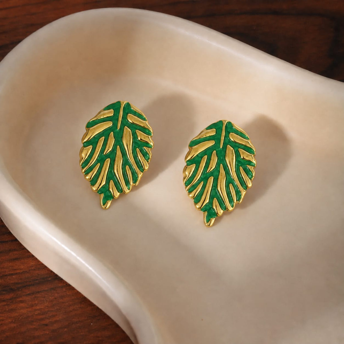leaf stud earrings featuring a textured metallic vein pattern