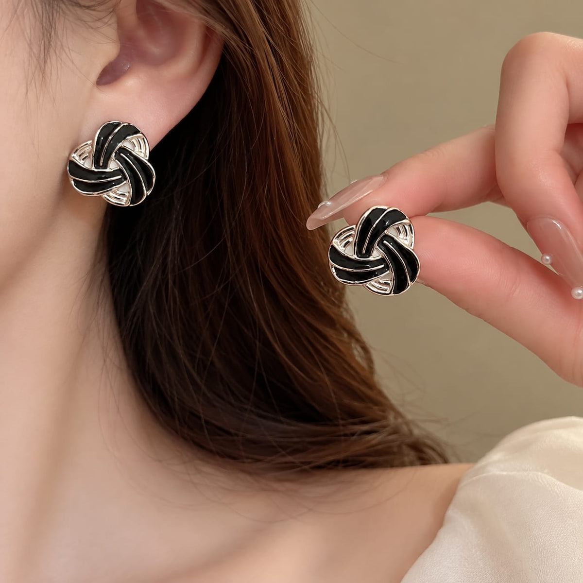 intertwined knot design accented with white enamel earring