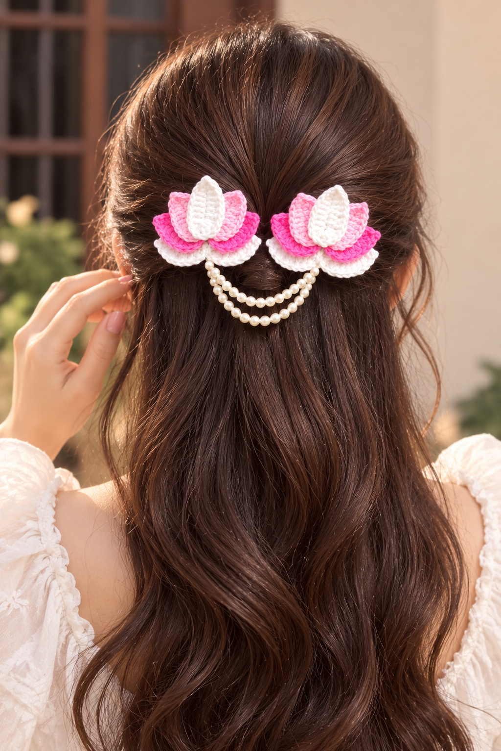 handmade crochet lotus flower hair clip featuring pink and white yarn petals connected by a double pearl bead chain