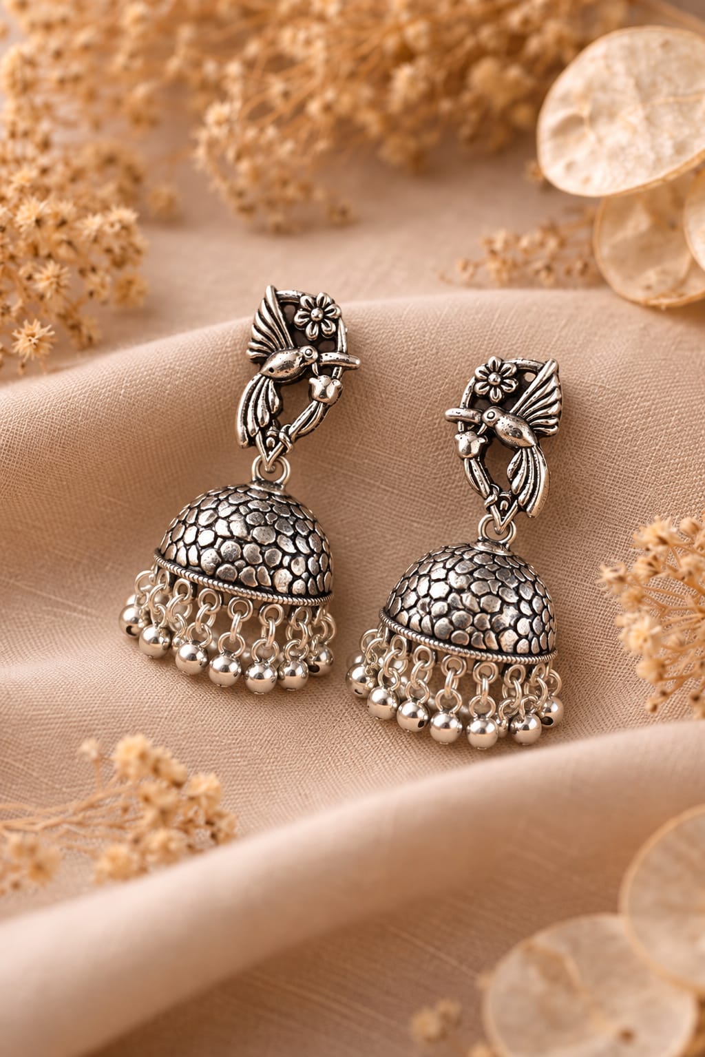 jhumka earrings with a detailed bird and floral stud design