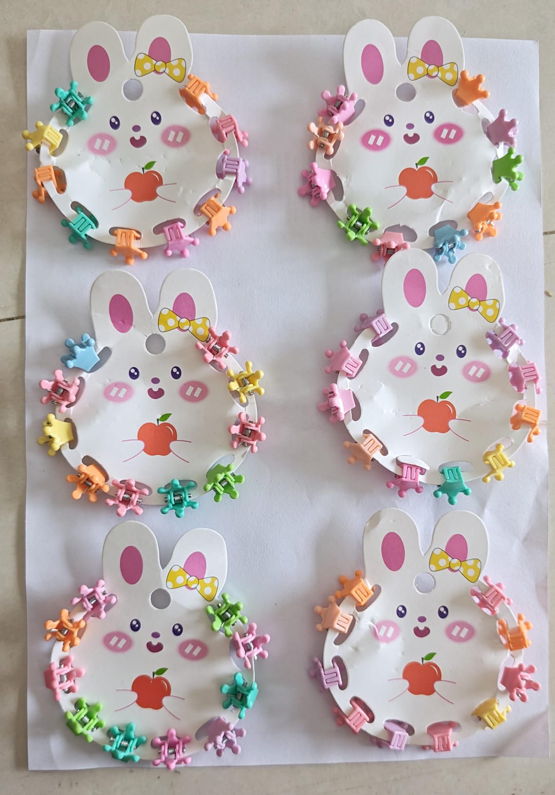 six bunny-themed display cards holding colorful mini plastic hair claw clips.